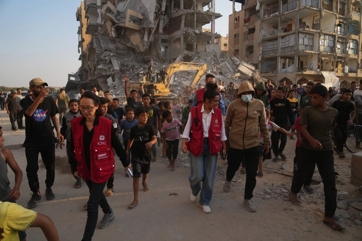Trabajadores de la Cruz Roja y palestinos trabajan en un área de la ciudad de Hamad, Khan Younis, en el sur de la Franja de Gaza, el 17 de octubre de 2025.
