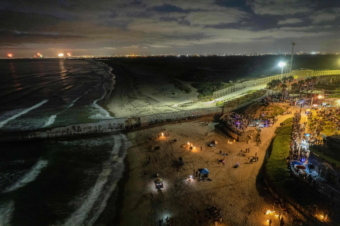 Personas reunidas para ver los fuegos artificiales de San Diego durante el Día de la independencia en los Estados Unidos, en la línea fronteriza México-EU, en Playas de Tijuana, en Baja California, México, el 4 de julio de 2022. Foto Afp