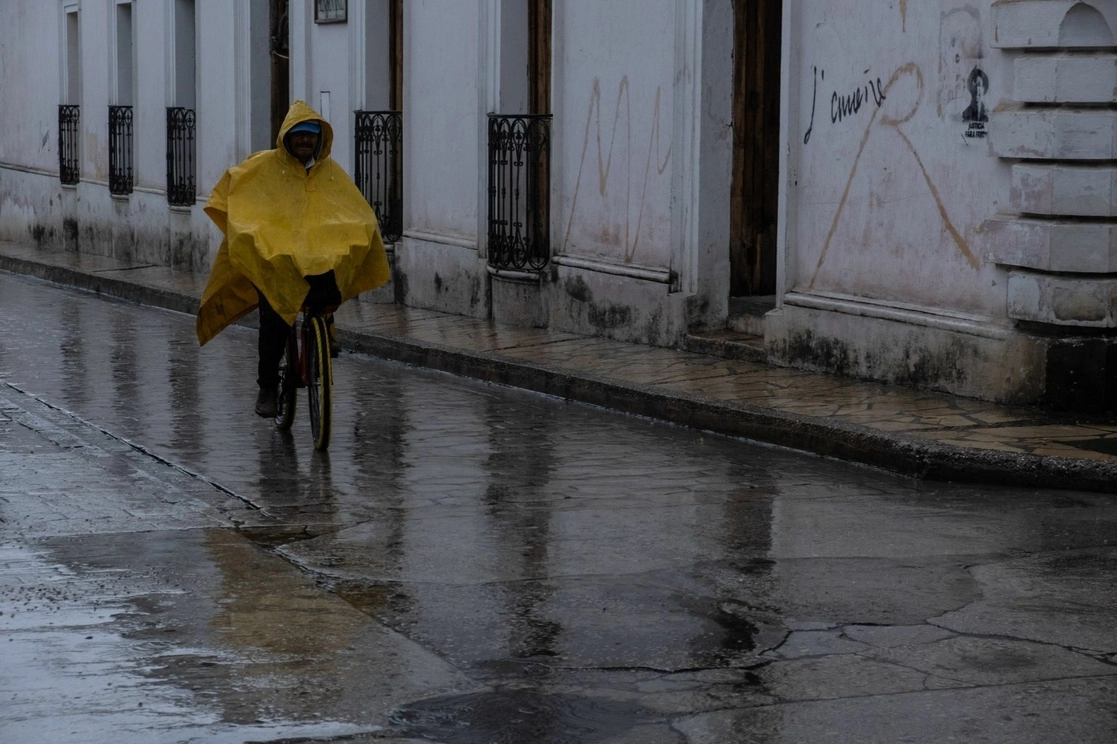 Un ciclista avanza bajo la lluvia en calles de San Cristóbal de las Casas, Chiapas. Foto Cuartoscuro