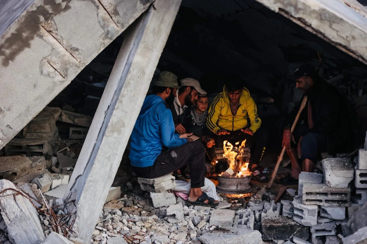 Habitantes desplazados en la ciudad de Gaza intentan calentarse, luego de que sus tiendas de campaña fueran destruidas por las intensas lluvias. Foto 