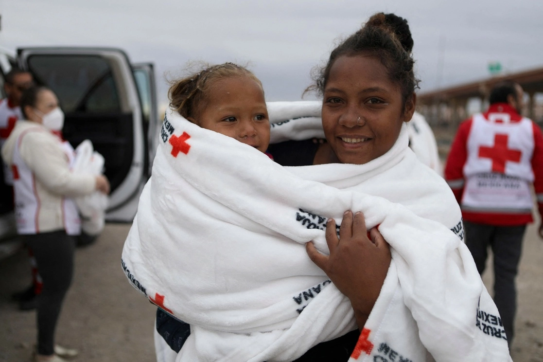 La Cruz Roja reparte cobijas entre migrantes en las orillas del Río Bravo, en Chihuahua. Foto Afp