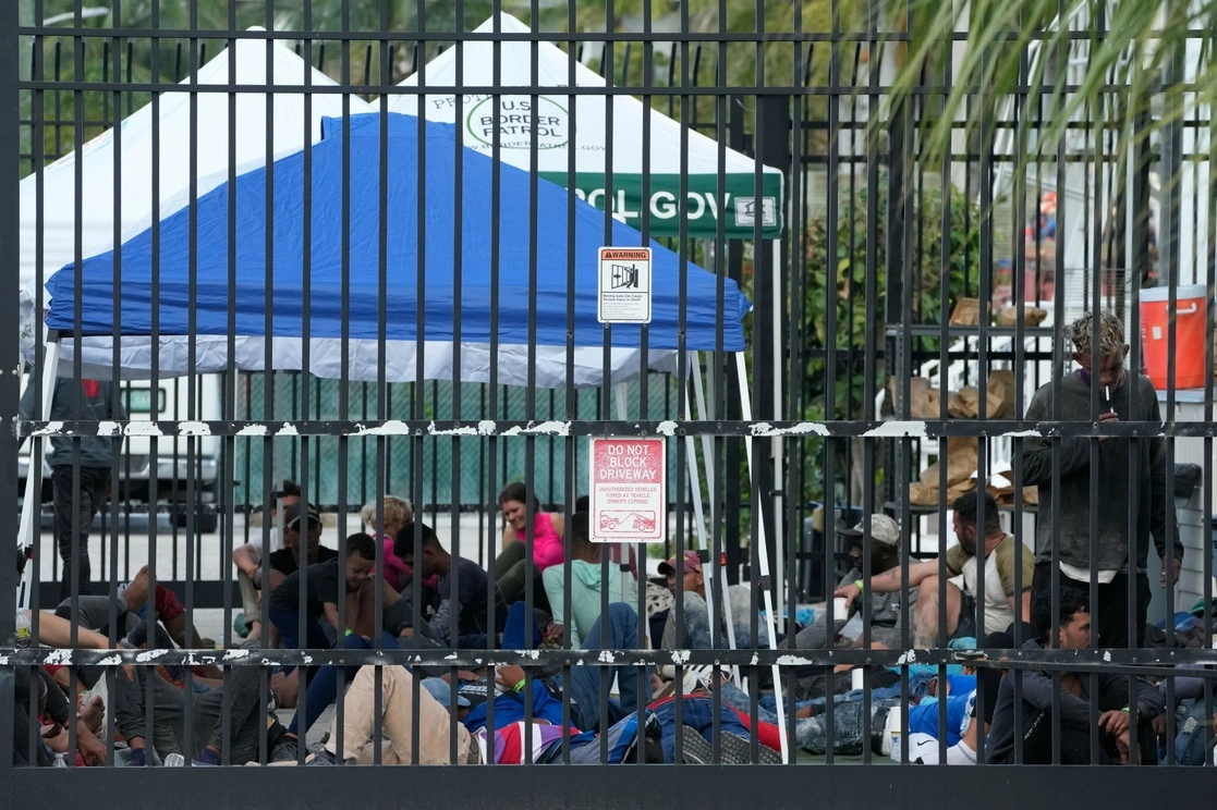Migrantes recién llegados esperan en una estación de la Patrulla Fronteriza, en Florida, EU. Foto Ap
