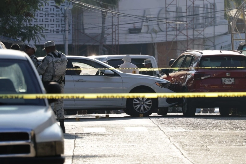 Elementos de la Guardia Nacional y peritos de la Fiscalía General del Estado de Guerrero, junto al vehículo del magistrado Edmundo Román, asesinado al salir del estacionamiento del Poder Judicial estatal, en Acapulco. Foto cortesía de Raúl Aguirre / ‘La Jornada’ Guerrero 