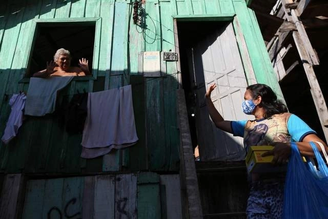Vecinas se saludan en Manaos, Brasil. Foto Afp

