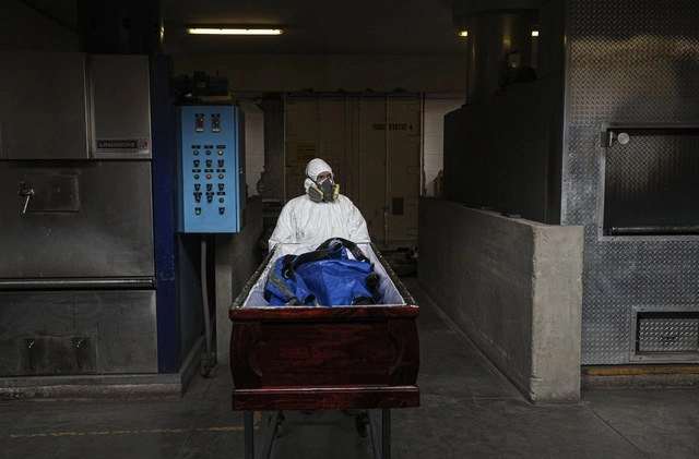 En Santiago, Chile, el empleado de un crematorio lleva a incinerar el cadáver de una persona fallecida por coronavirus. Foto Ap
