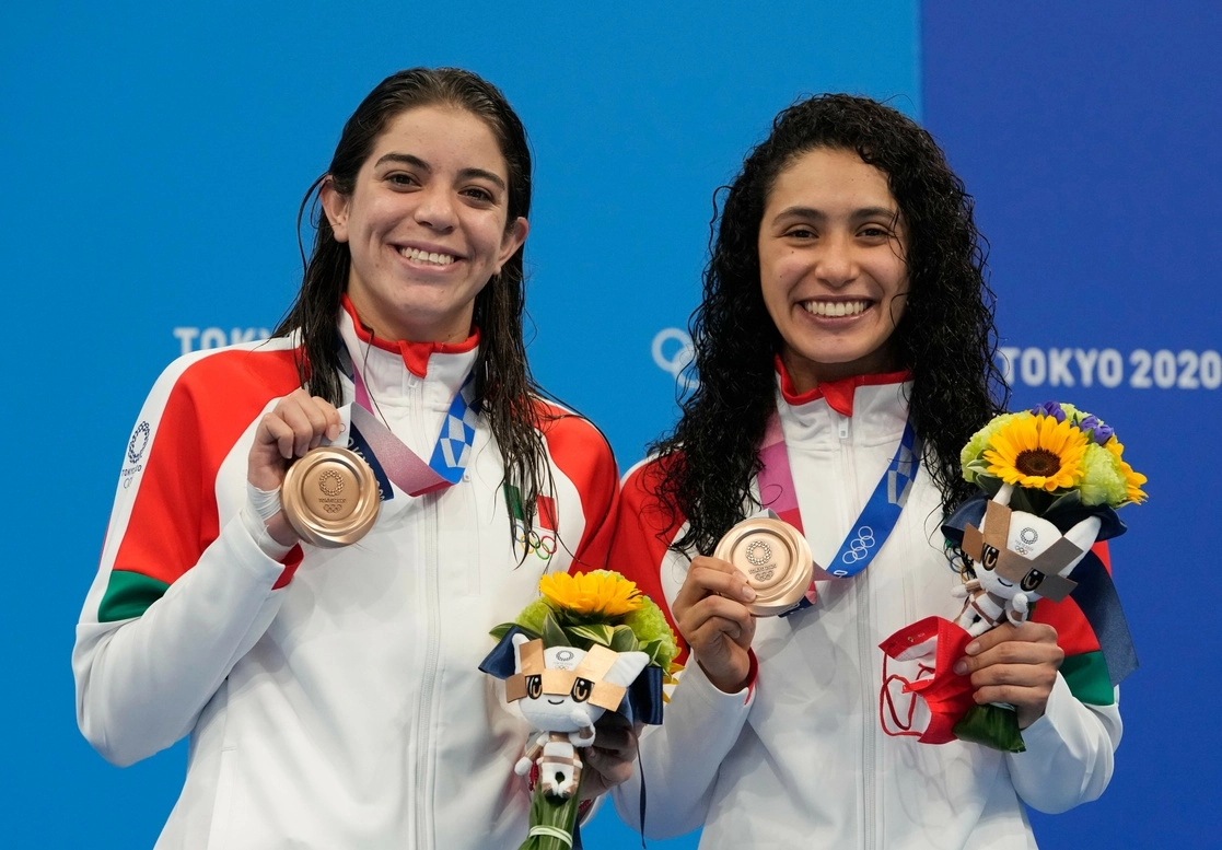 Alejandra Orozco y Gabriela Agúndez se quitaron los cubrebocas para posar felices con sus preseas que se colgaron ellas mismas en el podio compartido con el campeón China y Estados Unidos, plata, el 27 de julio de 2021. Es el segundo bronce para México en Tokio. Foto Ap
