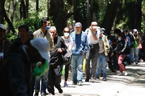 Cientos de personas hacen fila para acceder a una de las 260 raciones de alimentos que se entregan en el Comedor Móvil, instalado en el Jardín Ramón López Velarde, en la Ciudad de México. Foto Roberto García Ortiz/ archivo