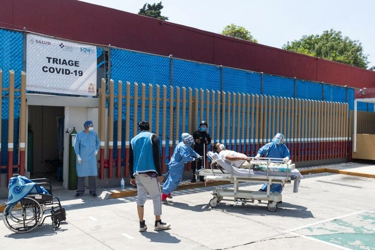 Trabajadores de la salud trasladan a un paciente con coronavirus al Hospital General, en la colonia Doctores. Foto Pablo Ramos