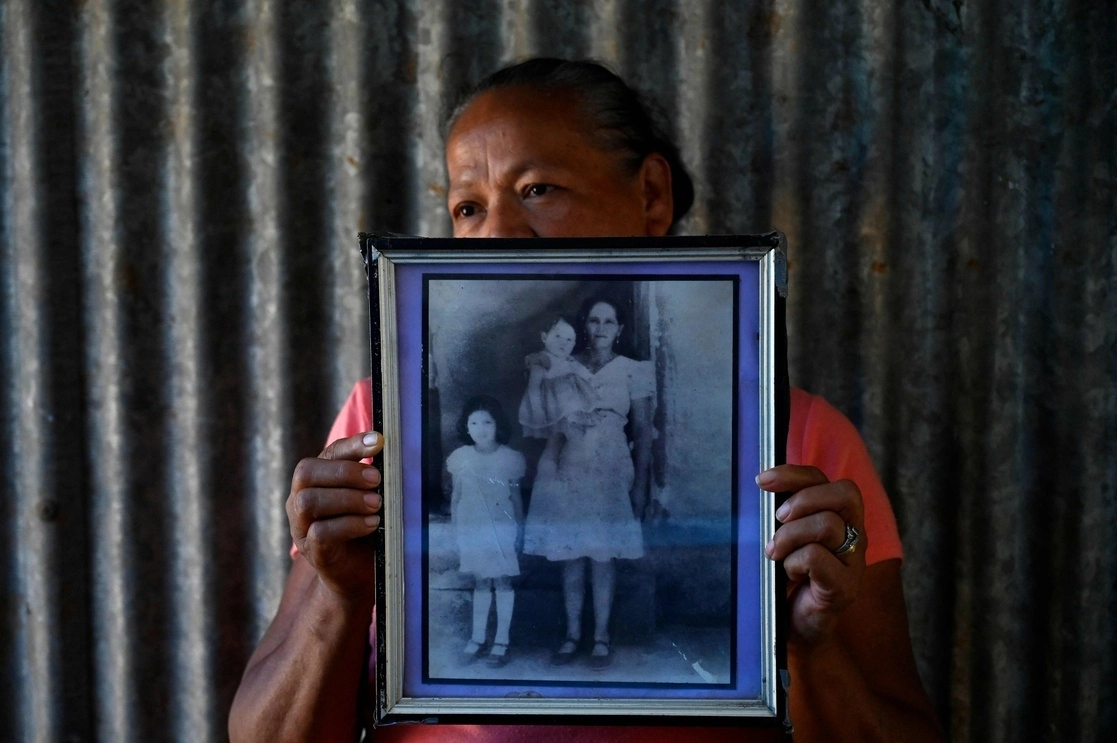 Miriam Núñez, de 63 años de edad, muestra la fotografía de dos de sus familiares asesinadas hace 40 años por militares salvadoreños en El Mozote. Foto Afp / Archivo
