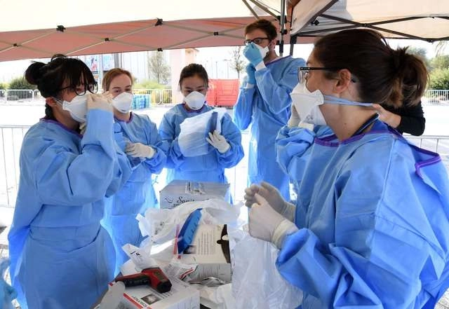 Estudiantes de medicina de la Universidad de Touro en Nevada se protegen antes de realizar pruebas de Covid-19 en un refugio de personas sin hogar. Foto Afp
