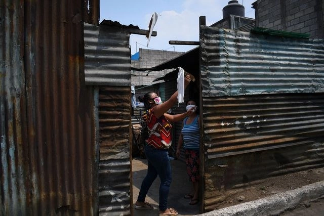 Vecinos colocan mantas en las fachadas de sus casas en los barrios más pobres de Guatemala y El Salvador, para pedir auxilio a falta de víveres. Foto Afp 