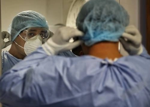 Un trabajador sanitario se alista para ingresar al área de enfermos de Covid-19 en el Hospital Juárez de México. Foto Marco Peláez