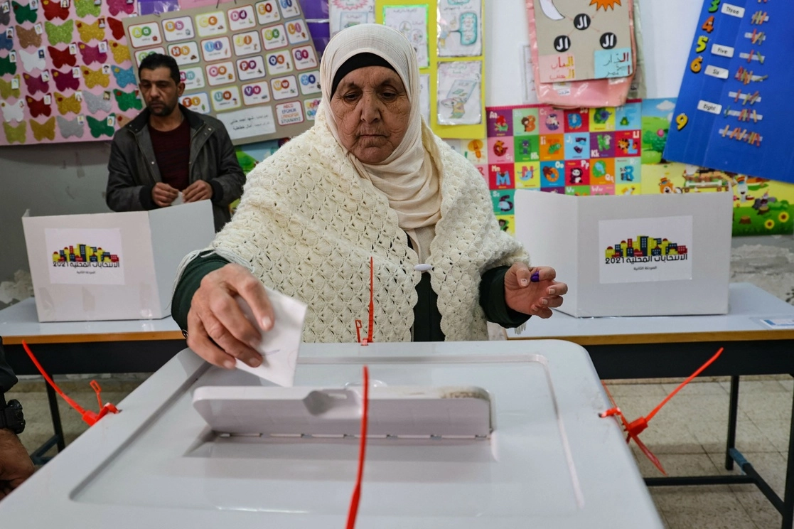 Una mujer emite su voto durante las elecciones de consejos municipales en Naplusa, Cisjordania. Foto Afp