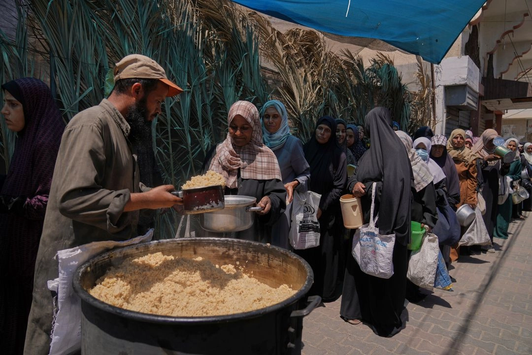 Mujeres palestinas reciben comida en un comedor de distribución de alimentos en Deir al-Balah, en la franja de Gaza, el 30 de mayo de 2025. Foto 