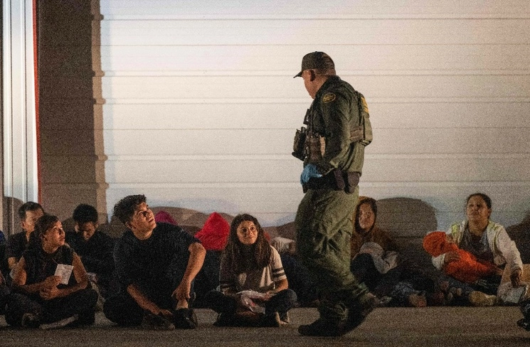 Migrantes esperan en Frontón, Texas, un autobús que los trasladará a un centro de procesamiento después de que se entregaron a los agentes de la Patrulla Fronteriza estadunidense luego de cruzar desde México. Foto Ap