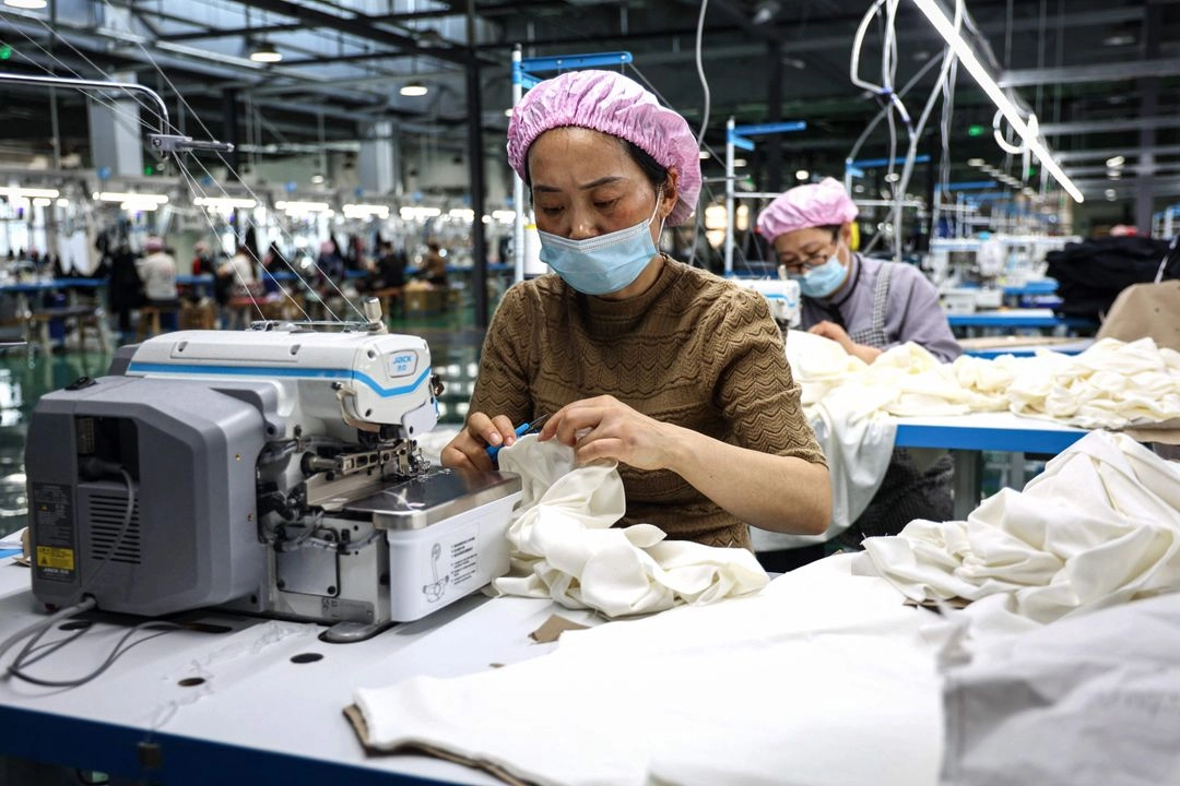 Una empleada de la industria del vestido elabora playeras en una fábrica en Binzhou, al este de China. 