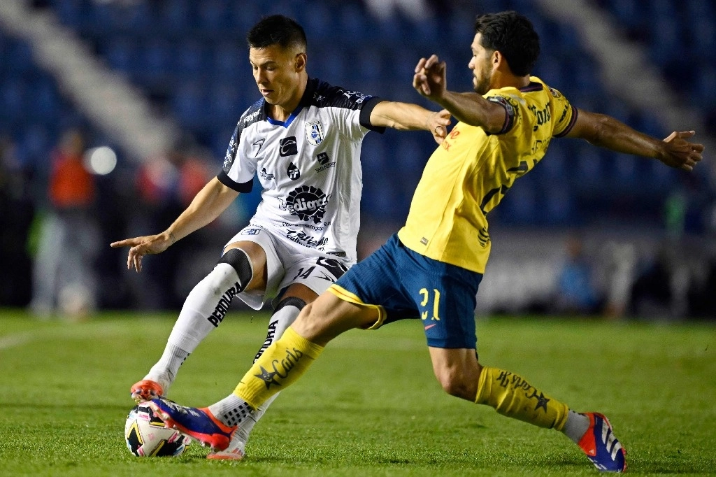 El mediocampista argentino de Querétaro, Federico Lertora (izq.) y el delantero de América, Henry Martin, luchan por el balón durante el partido de fútbol del torneo Apertura entre América y Querétaro en el estadio Ciudad de los Deportes en la Ciudad de México, el 12 de julio de 2024. Foto Afp