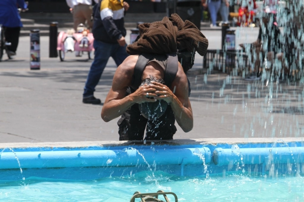Un hombre se refresca en una fuente de la plaza Liberación, en Guadalajara, Jalisco, para mitigar el calor extremo en la entidad. Además, tras la llegada de la tercera ola cálida al país, estados como Nuevo León registraron ayer temperaturas de más de 40 grados. Foto Arturo Campos Cedillo
