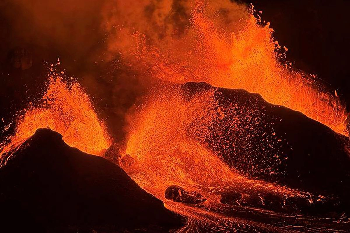 Vista nocturnas de fuentes de lava provenientes del cráter Haleumaumau en la cima del volcán Kilauea, dentro del Parque Nacional de los Volcanes de Hawái.