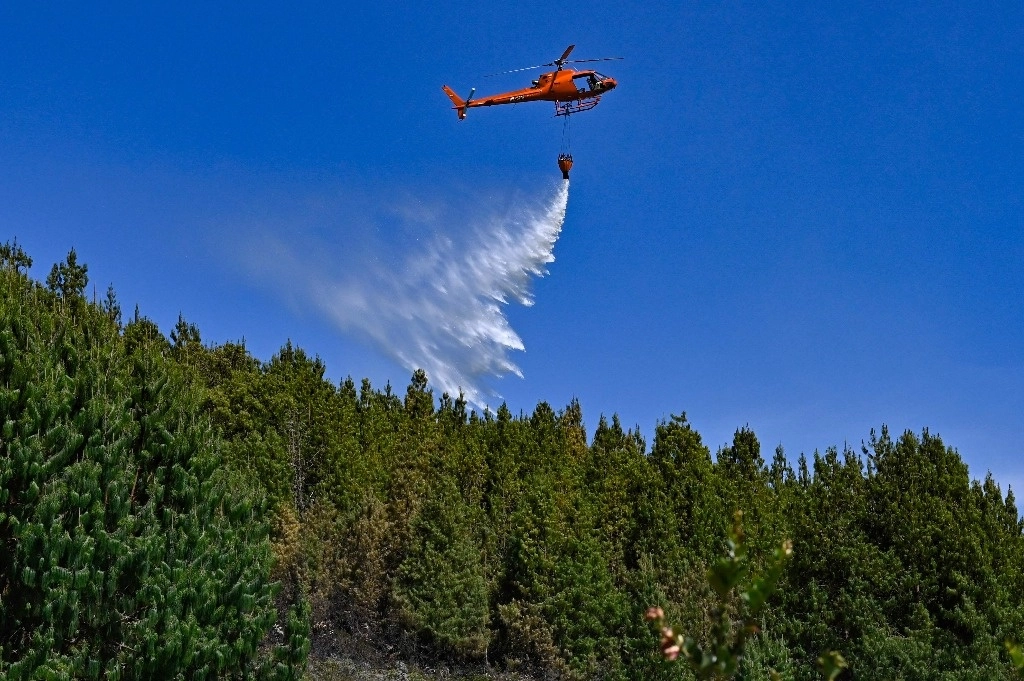 Un helicóptero arroja agua para mitigar un incendio forestal en Nemocon, Colombia, en imagen de antier. Foto Afp 