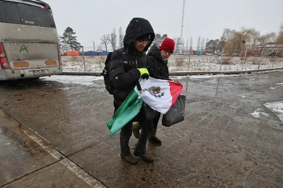 Un par de ciudadanos mexicanos, que solicitaron ser repatriados debido a la guerra entre Rusia y Ucrania, atraviesan la frontera de esta última nación hacia Siret, ciudad rumana, a principios de marzo de 2022. Foto Marco Peláez