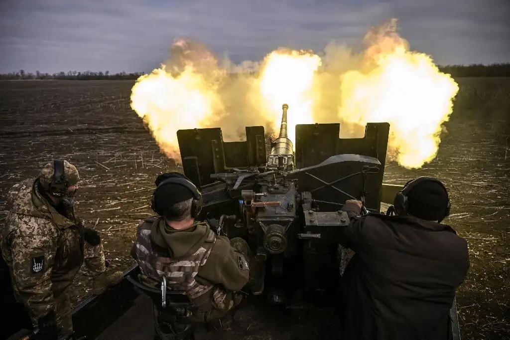 Solados ucranios disparan un arma antiaérea contra posiciones rusas cerca de Bakhmut, el 20 de marzo de 2023. Un pequeño grupo de viejos amigos ha restaurado una pieza de artillería de la década de 1950 para luchar juntos en el frente. Los seis hombres disparan un cañón S-60 de 57 mm de la era soviética, una pieza que suele verse en las entradas de las grandes ciudades en las rotondas o en los edificios oficiales. Foto Afp
