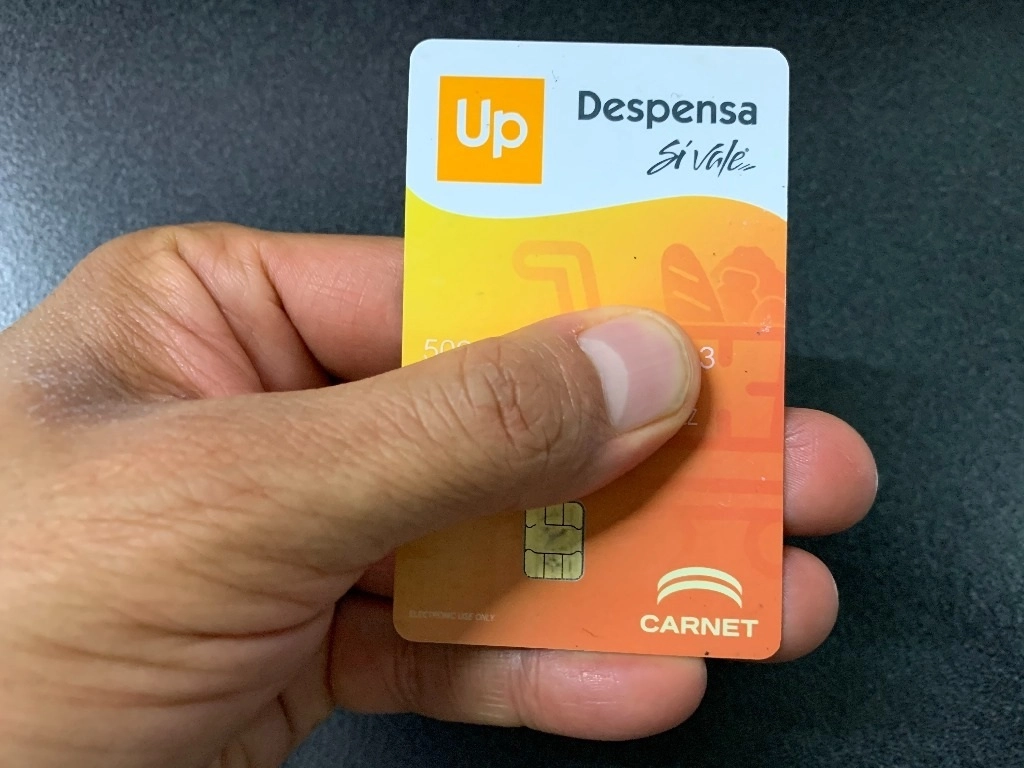 Persona sostiene una tarjeta de vales de despensa en imagen de archivo. Foto La Jornada 
