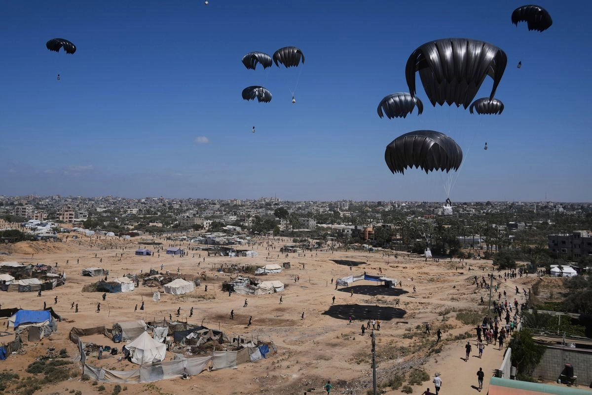 Palestinos se apresuran a recoger la ayuda humanitaria lanzada desde el aire sobre Zawaida, en el centro de la franja de Gaza, el 31 de julio de 2025. Foto 
