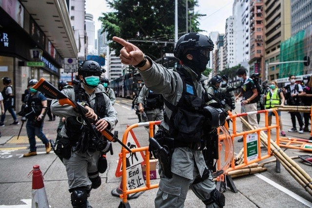 Policías antidisturbios recogen los escombros tras la protesta prodemocracia en Hong Kong, en imagen de ayer. Foto Afp