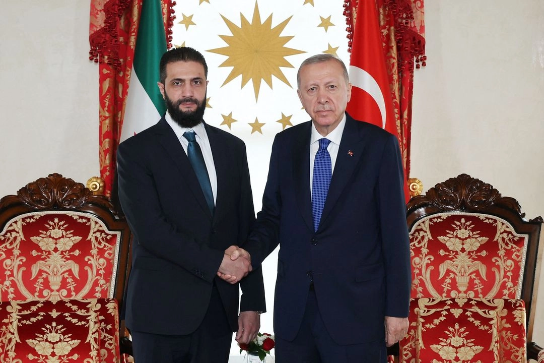 El presidente turco, Recep Tayyip Erdogan y el líder de Hayat Tahrir al-Sham (HTS), Ahmed al-Sharaa (izquierda), estrechándose la mano durante su reunión.