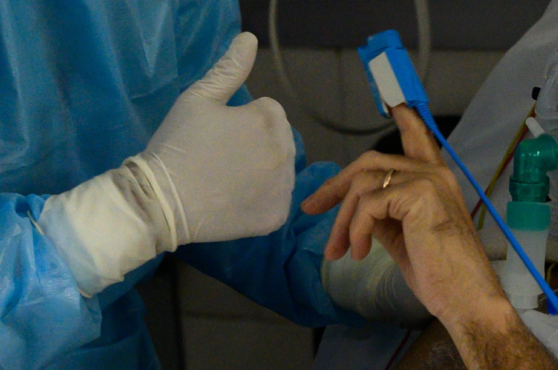 Un doctor da el visto bueno a un paciente de coronavirus que le enseña el oxímetro, en un hospital privado de Montevideo, Uruguay, país que en los últimos 14 días ha mantenido el mayor número de muertes per cápita en el mundo. Foto Afp / Archivo