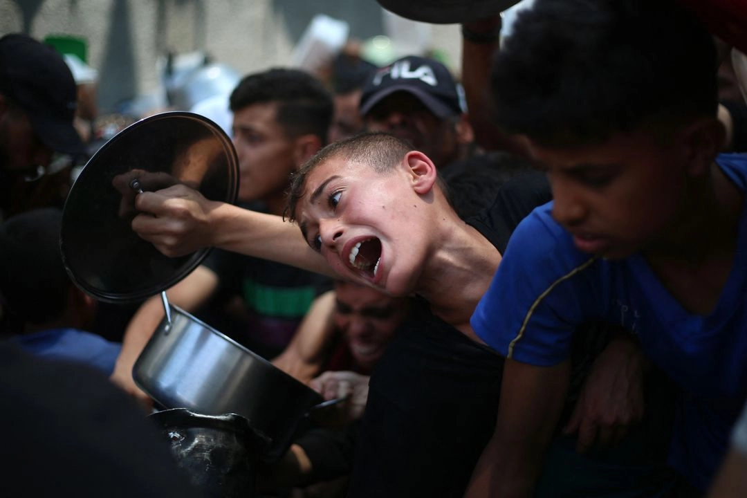 Niños palestinos esperan comida en un punto de distribución en Nuseirat, en el centro de la franja de Gaza, el 11 de junio de 2025. Foto 