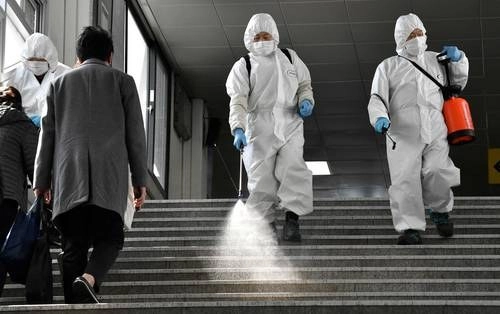  Trabajadores con equipos de protección rocían desinfectante en aerosol en una estación del Metro en Seúl para ayudar a prevenir la propagación del Covid-19. Foto Afp