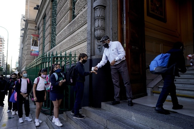 Niños hacen fila para entrar a la escuela, en medio de la pandemia en Buenos Aires, pese a la orden presidencial de suspender las clases durante dos semanas. Foto Ap