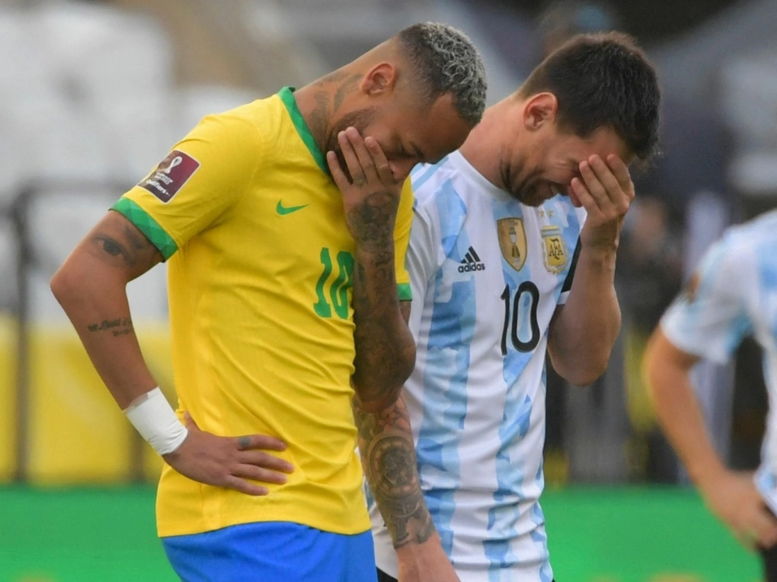 Los astros Neymar y Lionel Messi se muestran incrédulos luego de que integrantes de la Agencia Nacional de Vigilancia Sanitaria de Brasil entraran al terreno de juego, apenas al minuto cinco, en el estadio de Sao Paulo, el 5 de septiembre de 2021. Foto Afp
