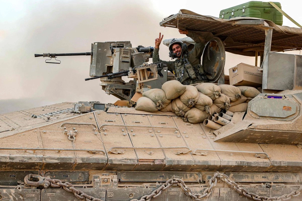 Un soldado del ejército israelí sonríe en un vehículo de combate de infantería (VCI) en una posición a lo largo de la valla fronteriza con la Franja de Gaza, en el sur de Israel, el 12 de septiembre de 2025. 