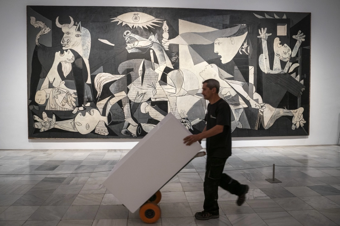 Un trabajador pasa junto al ‘Guernica’, después de la presentación del Año Picasso en el Museo Reina Sofía. Foto Ap 