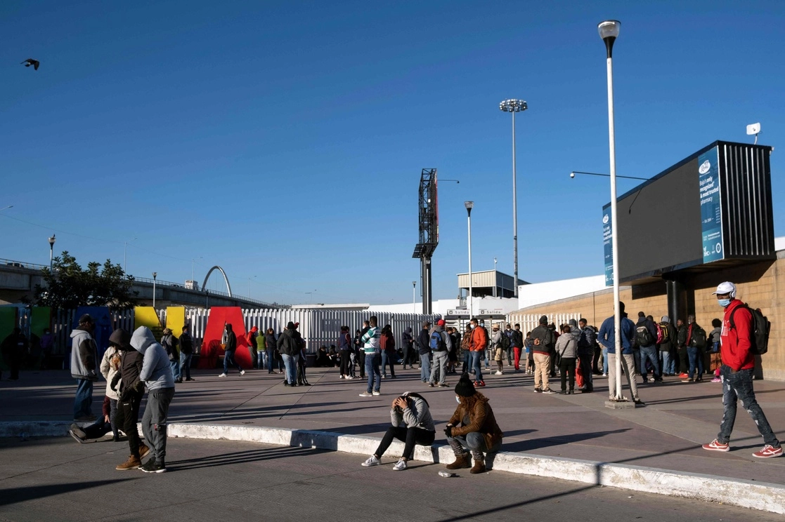 Solicitantes de asilo que esperan cruzar a los Estados Unidos se reúnen frente al puerto de cruce de El Chaparral en Tijuana, Baja California, el 22 de febrero de 2021. Foto Afp
