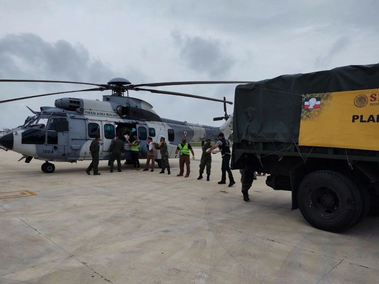 Ante las fuertes lluvias que se han registrado en Quintana Roo, la Sedena desplegó elementos del Ejército y Fuerza Aérea y estableció un puente aéreo para el traslado de familias de diversas comunidades a sitios seguros, así como para el reparto de despensas. Foto Sedena
