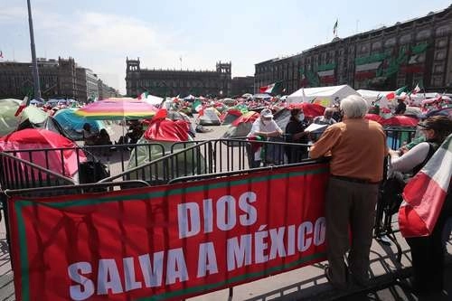 Algunos de los integrantes del grupo Frena que marcharon ayer observan las tiendas de campaña instaladas en la Plaza de la Constitución. Foto José Antonio López