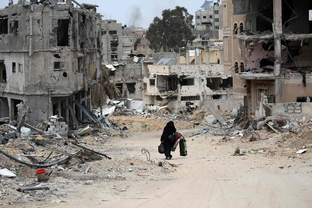 Una mujer palestina camina por un barrio devastado por los bombardeos israelíes en Khan Yunis, en el sur de la Franja de Gaza, el 25 de abril de 2024. Foto Afp