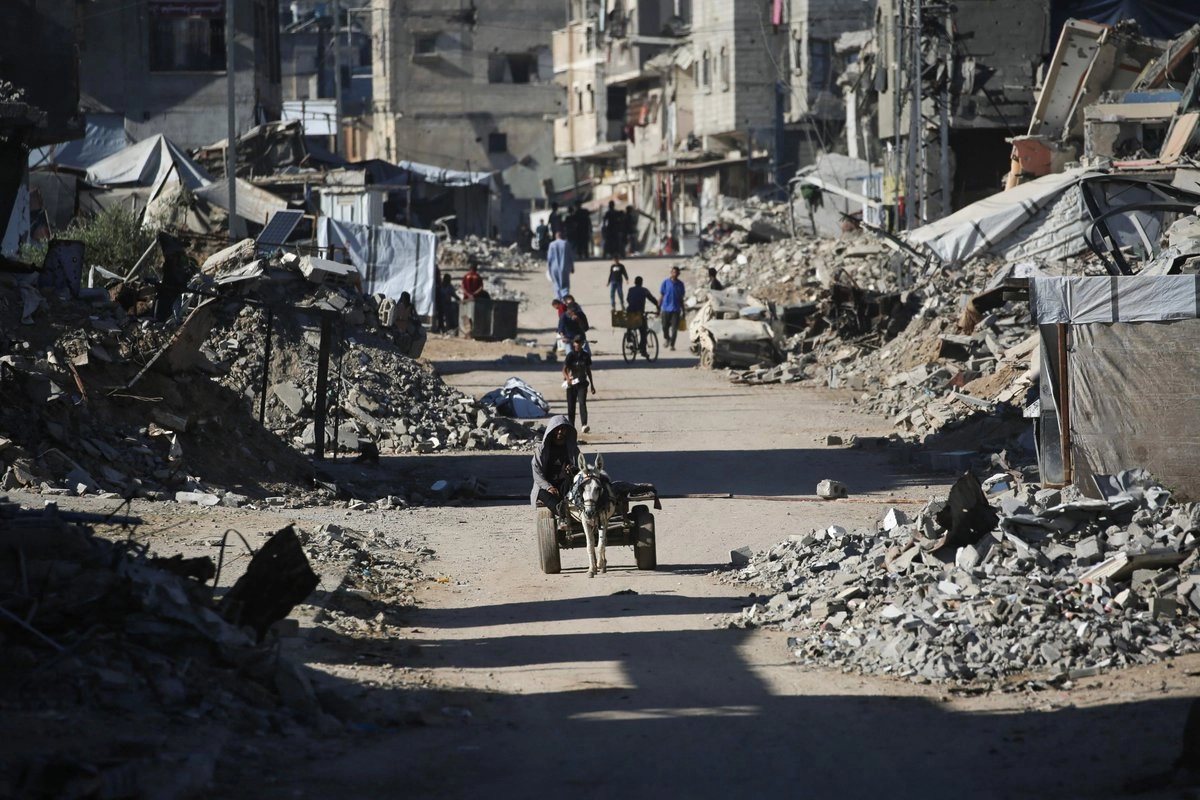 Palestinos desplazados regresan a sus hogares en la zona de Al-Zahra, al norte del campo de refugiados de Nuseirat, en el centro de la Franja de Gaza, el 14 de octubre de 2025.
