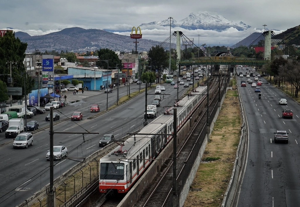 El volcán Iztaccíhuatl visto desde la alcaldía Iztapalapa, donde peatones se subieron a un puente peatonal para llevarse el recuerdo del paisaje en la Ciudad de México, el 12 de enero 2025. Foto Jair Cabrera Torres 