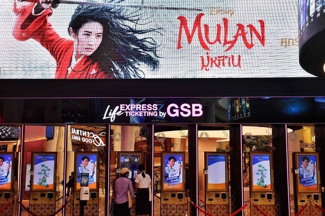 Personas compran boletos para la película de ‘Mulán’ en Bangkok. Foto Afp