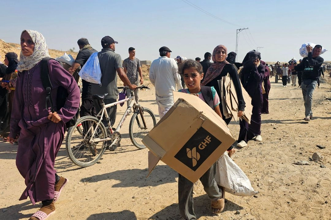 Palestinos desplazados caminan por una carretera para recibir paquetes de ayuda humanitaria de una fundación respaldada por Estados Unidos en Rafah, en el sur de la franja de Gaza, el 5 de junio de 2025.  Foto 