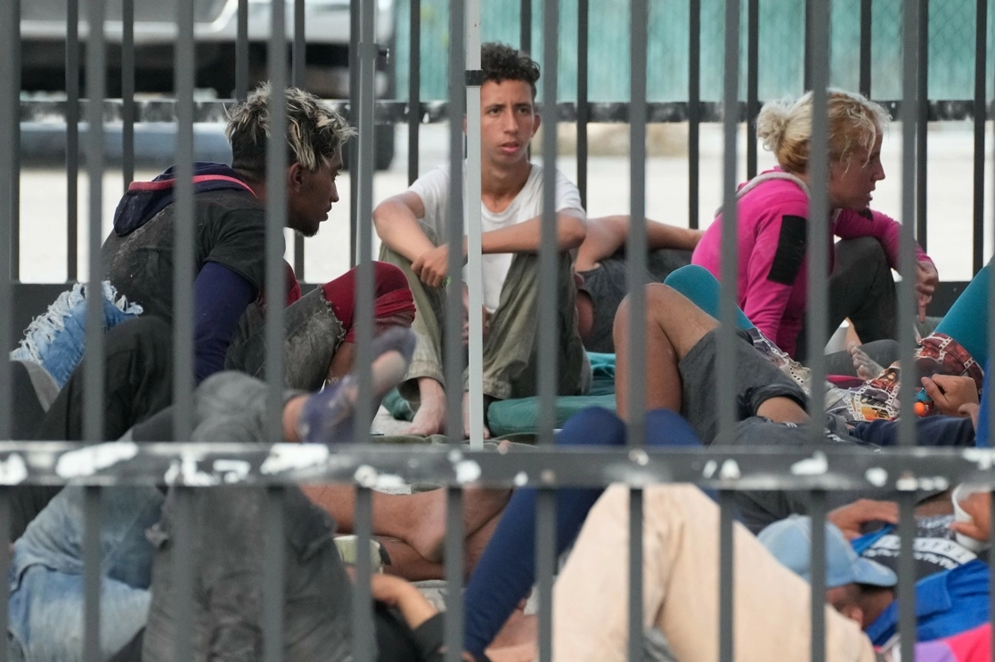 Migrantes recién llegados esperan en una estación de la Patrulla Fronteriza en Florida, EU. Foto Ap 