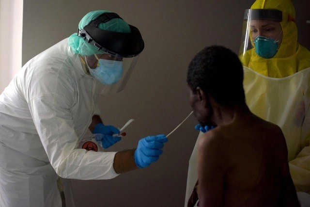 En  Texas, EU, un trabajador médico toma muestra de paciente para realizar la prueba de detección de Covid-19. Foto Afp