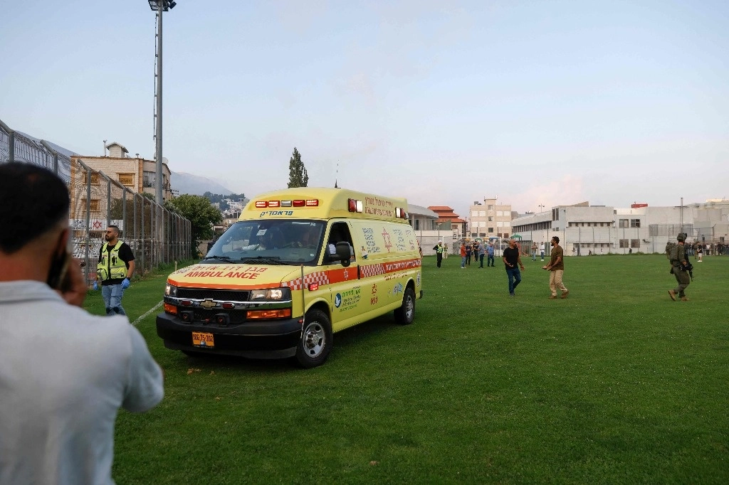 Las fuerzas de seguridad y los médicos israelíes transportan a las víctimas desde un lugar donde se informó que cayó un ataque desde el Líbano en la aldea de Majdal Shams en los Altos del Golán anexada por Israel, el 27 de julio de 2024. Foto Afp