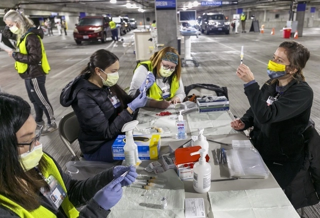 Médicos preparan dosis de la vacuna de coronavirus en una clínica en Portland, Estados Unidos. Foto Ap / Archivo