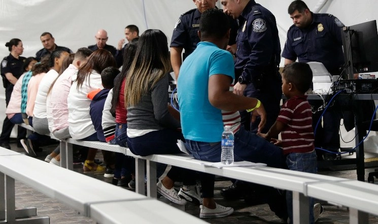 Migrantes que solicitan asilo en EU pasan por un área de procesamiento en una nueva sala de audiencias en el Centro de Audiencias de Inmigración de los Protocolos de Protección Migratoria, en Laredo, Texas. Foto AP / archivo